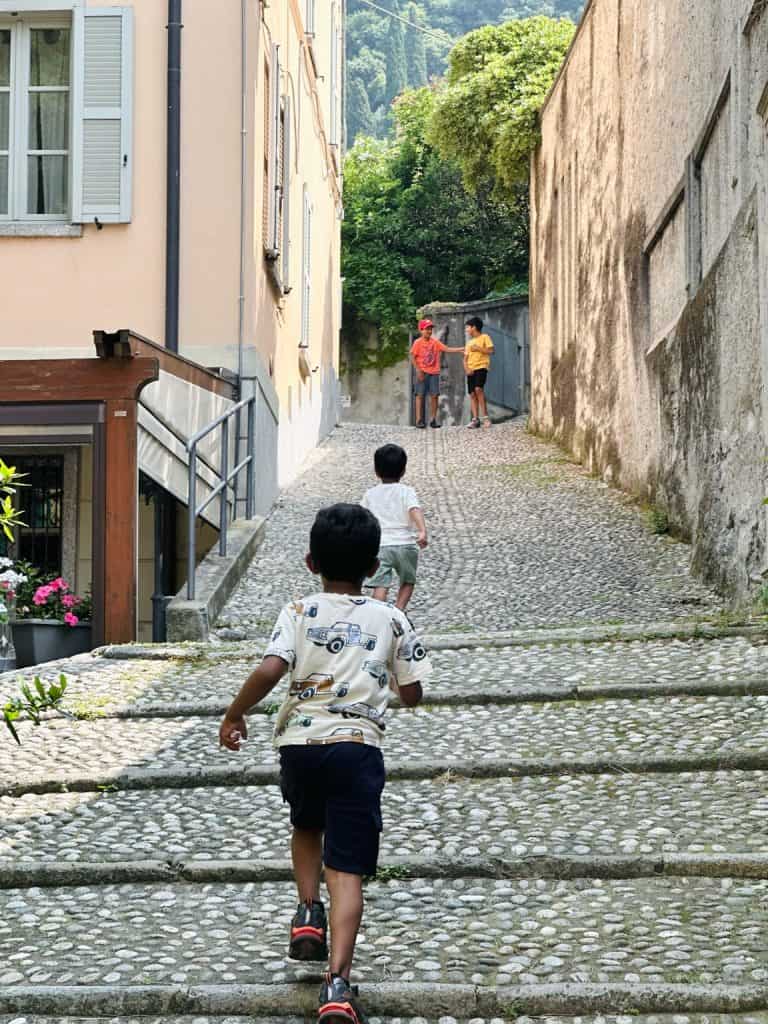 Kids exploring a city street from behind — a travel experience we’re saving for when kids are a little older